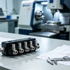 PEEK and stainless steel medical CNC manifold assembly on clean metrology workbench, precision fluid delivery component